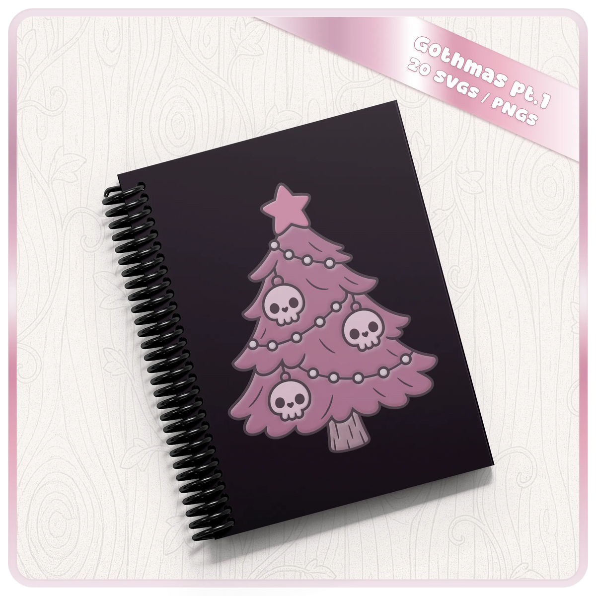 Pink Gothic Christmas tree with skull baubles displayed on a black spiral notebook, showcasing a cute pastel goth Christmas SVG design for personalised crafts.