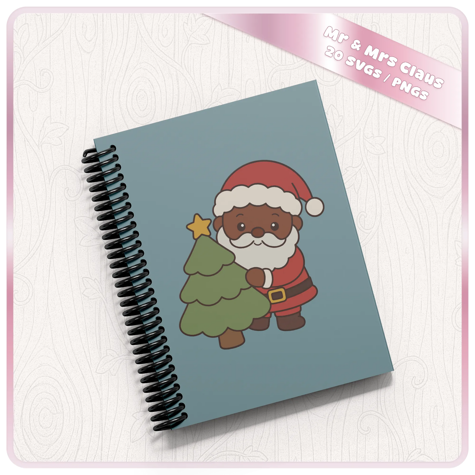 Christmas Santa SVG mockup on a blue spiral notebook featuring a cute brown skin Santa Claus holding a decorated Christmas tree from the 20 design SVG and PNG bundle.